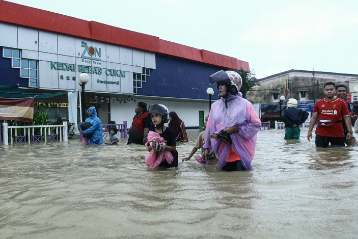  eople wade through floodwaters past a duty free shop in alaysias northeastern town of antau anjang which borders hailand on anuary 3 2017      alaysia 