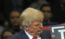 Donald Trump holds a 'Trump Digs Coal' sign during a rally in 2016.