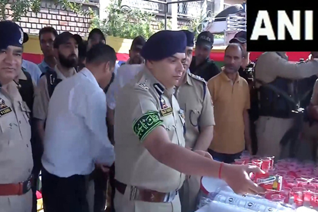 Srinagar: Senior police officials distribute water among Shia mourners participating in Muharram procession