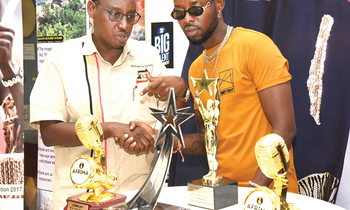 Eddy Kenzo ku ddyo ng'alaga Stephan Asiimwe engule ze yawaddeyo eri aba Uganda Museum Eddy Kenzo ku ddyo ng'alaga Stephan Asiimwe engule ze yawaddeyo eri aba Uganda Museum