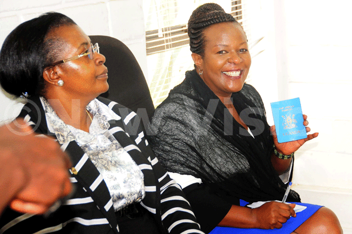 ora yamukama  shows her ast frican passport as the former  peaker argaret ziwa looks on during a press rief at the media center on 7th pril 2016 ictures by icholas neal