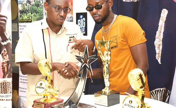Eddy Kenzo ku ddyo ng'alaga Stephan Asiimwe engule ze yawaddeyo eri aba Uganda Museum Eddy Kenzo ku ddyo ng'alaga Stephan Asiimwe engule ze yawaddeyo eri aba Uganda Museum