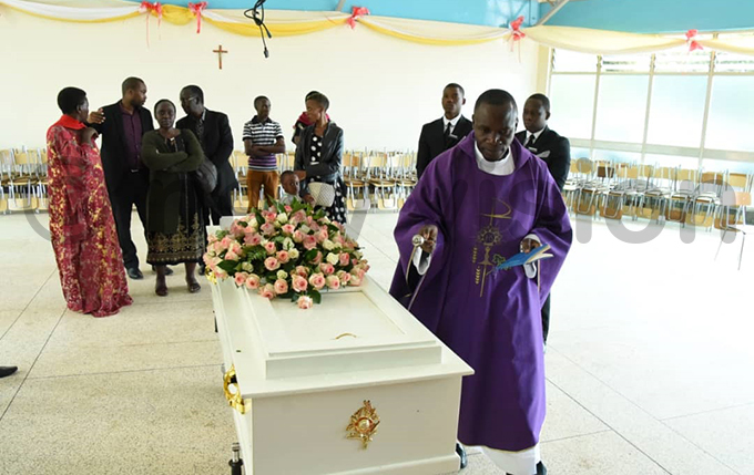 ev r nthony ibira sprinkling the casket containing athy gabas remains with holy water hoto by palanyi sentongo