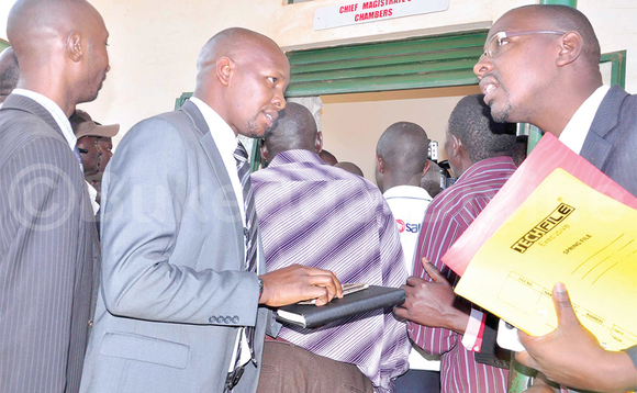 Matovu Junior (wakati) avunaana Bujingo okwokya Bayibuli ng’ali ne looya we Wameri (ku ddyo) eggulo ku kkooti. Matovu Junior (wakati) avunaana Bujingo okwokya Bayibuli ng’ali ne looya we Wameri (ku ddyo) eggulo ku kkooti.