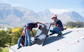 A team of workers install brackets for solar panels on the roof of a house in Cape Town | Credit: iStock