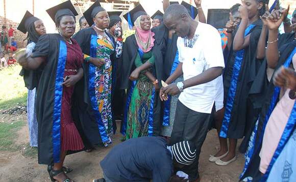 Omusajja ng'asiimuula engatto z'Omulangira Herbert Kimbugwe ku mukolo. Omusajja ng'asiimuula engatto z'Omulangira Herbert Kimbugwe ku mukolo.