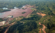 Aerial of a mine tailings reservoir in Magadascar, receiving slurry through a pipeline from an ore processing plant.