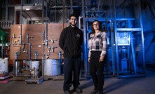 Patrick Mankarious and Maritza Valencia Bejarano stand in front of the autoclave