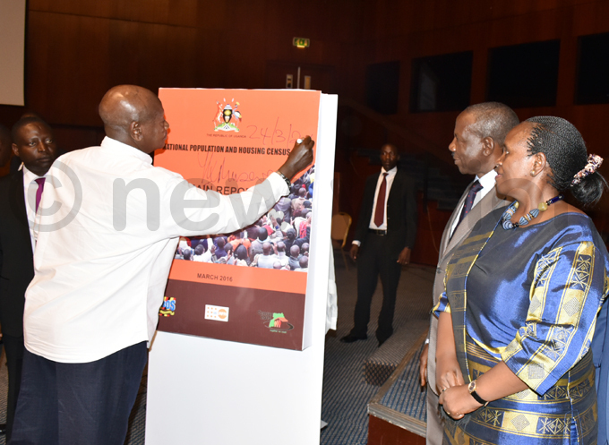  resident oweri useveni signs a dummy copy of the 2014 ensus report hoto by oderick himbazwe