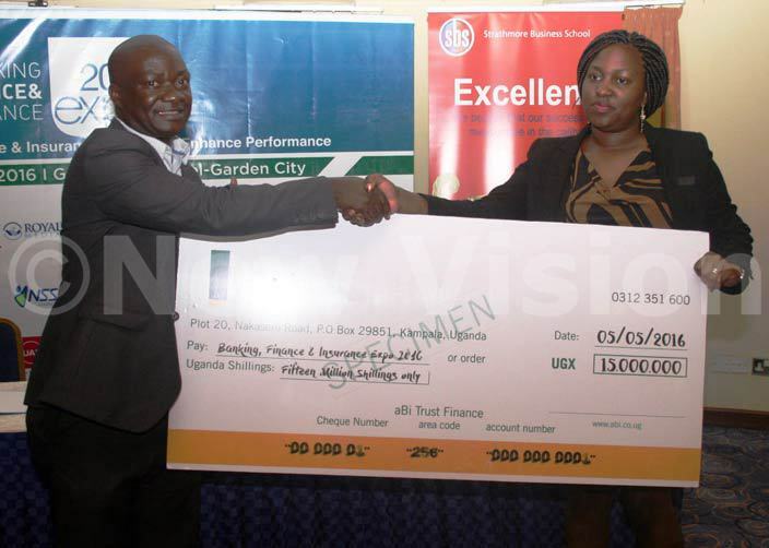  avid empala chief executive officer at oyal way media receives a shs 15 million dummy cheque for the banking xpo at olf ourse otel from a representative from bi rust hoto by yet kwera