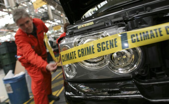 John Sauven labels a SUV on the Range Rover production line as 'Climate Crime Scene'. © Kate Davison / Greenpeace