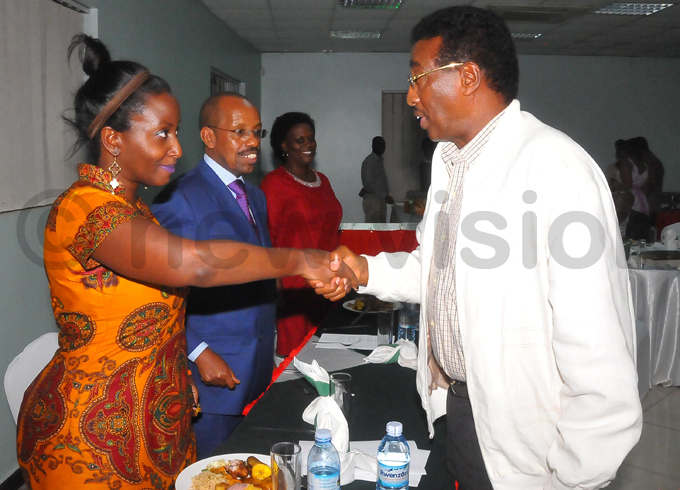 uth dyabahika  chats with aj en im uhwezi during the dinner entre is the ermanent ecretary in the inistry of inance eith uhakanizi  hoto by ilfred anya