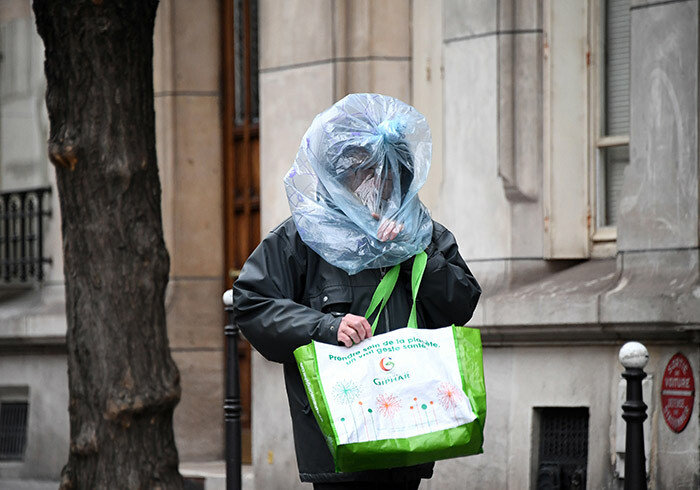 man protect his face with a plastic bag as he walks in the street in aris on arch 21 2020 as a strick lockdown comes into in effect to stop the spread of the 19 in the country rench resident asked people to stay at home to avoid the spreading the ovid19 saying only necessary trips would be allowed and violations would be punished he country has already shut cafes restaurants schools and universities and urged people to limit their movementnonessential public places including restaurants and cafes hoto by