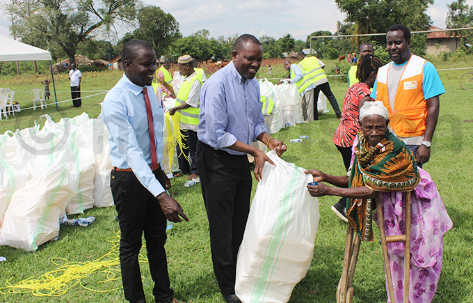 utaleja resident district commissioner immy bil segawa handing over relief items to a beneficiary hoto by eorge ita