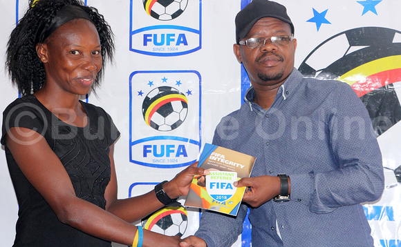 Moses Magogo pulezidenti wa FUFA ng'akwasa ddifiiri Lydia Nantabo bbaagi ya FIFA ey'omwaka 2018. Nantabo y'omu ku baddiifiiri 21 abafuunye bbaagi ez'omutendera gw'ensi yonna ez'abakwasiddwa ku Lwokusatu nga December 27 ku kitebe kya FUFA e Mengo. (STEPHEN MAYAMBA) Moses Magogo pulezidenti wa FUFA ng'akwasa ddifiiri Lydia Nantabo bbaagi ya FIFA ey'omwaka 2018. Nantabo y'omu ku baddiifiiri 21 abafuunye bbaagi ez'omutendera gw'ensi yonna ez'abakwasiddwa ku Lwokusatu nga December 27 ku kitebe kya FUFA e Mengo. (STEPHEN MAYAMBA)