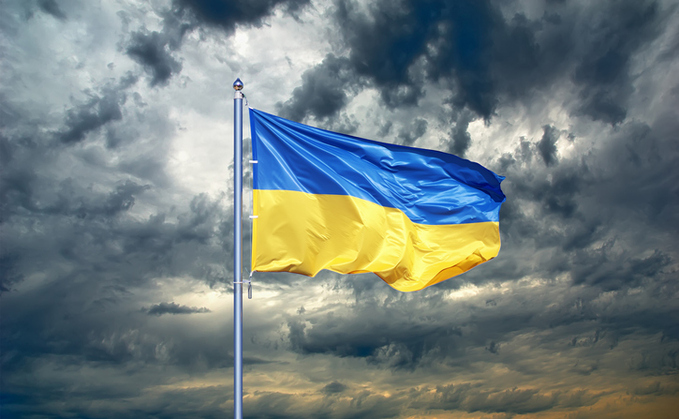 Ukrainian flag flying against a black, cloudy sky