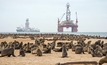 A seals colony against an ocean near Walvis bay, Namibia, with a diamond mining vessel in the background.