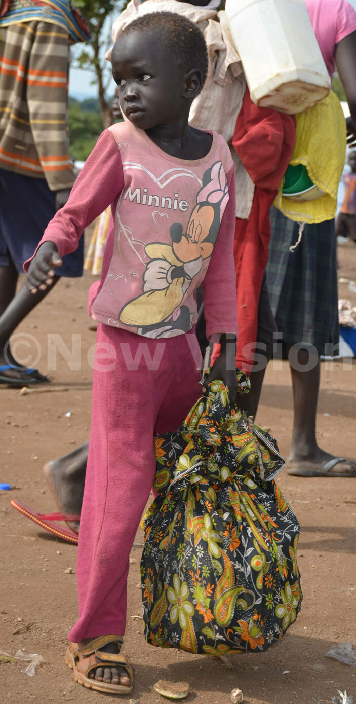   boy carrying his luggage to a truck at the reception centre to take him idibidi settlement in umbe district 
