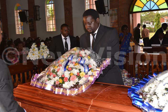  uwanguzis son oah who spoke on behalf of his siblings lays a wreath on his fathers casket hoto by achel wagala