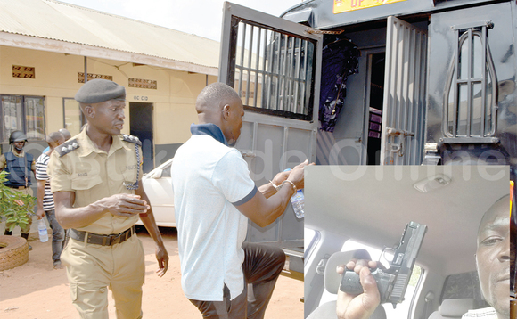 Sobi (mu kifaananyi ku mpingu) nga bamulinnyisa akamotoka ka poliisi okumutwala e Nalufenya. Ku ddyo ng’akutte emmundu. Sobi (mu kifaananyi ku mpingu) nga bamulinnyisa akamotoka ka poliisi okumutwala e Nalufenya. Ku ddyo ng’akutte emmundu.