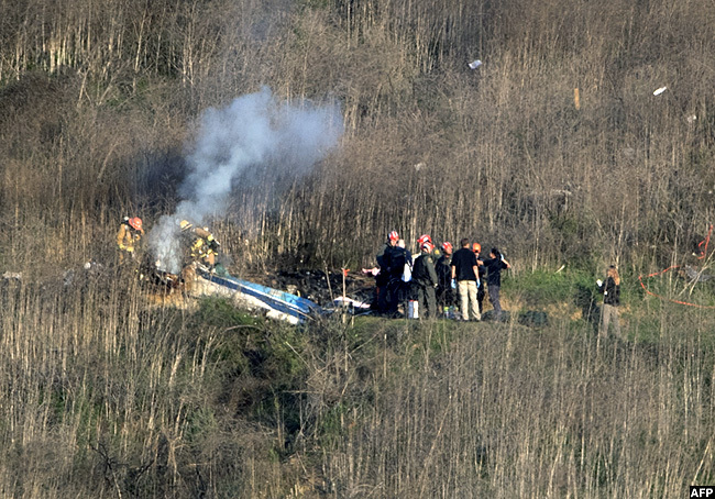   ounty ire epartment firefighters and coroner staff check the wreckage at the scene of the helicopter crash in alabasas