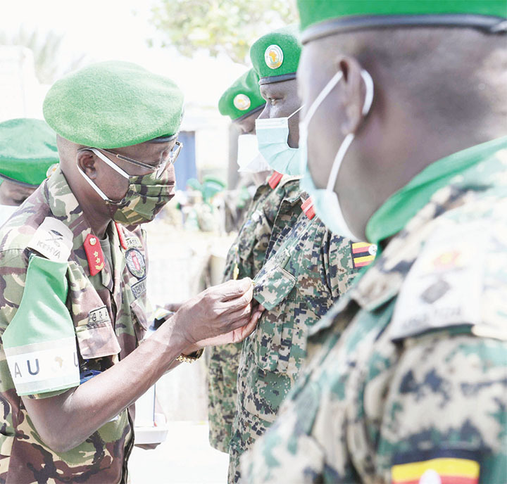 Maj. Gen. Owinow pins a medal on a Ugandan military officer