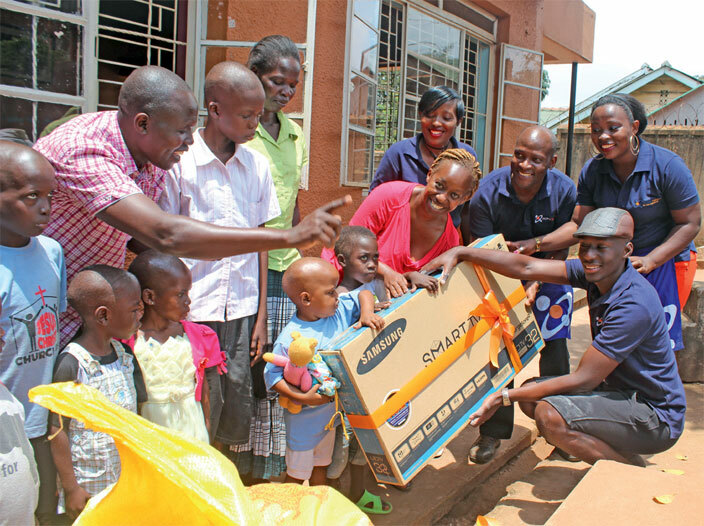 oke elkom staff handing over a television to the children of less a hild oundation in waise this month 