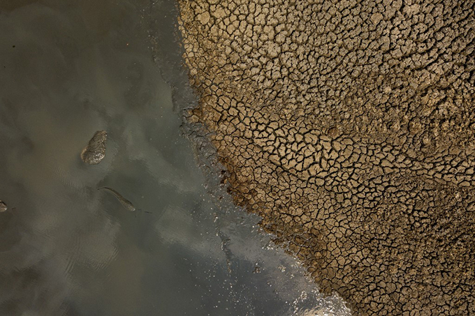 n aerial photograph shows fish flipping in the mud at a drying watering hole in the wange ational ark in imbabwe  hoto