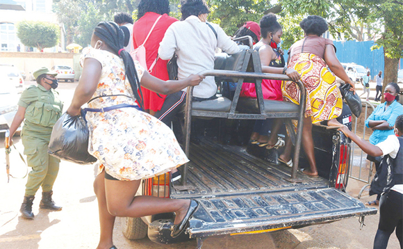 Abamu ku ba saluuni abaakwatiddwa nga batuusibwa ku poliisi ya CPS. Abamu ku ba saluuni abaakwatiddwa nga batuusibwa ku poliisi ya CPS.