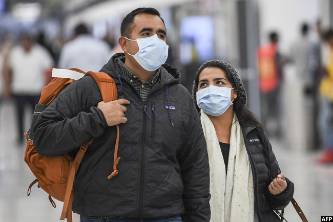  assengers wear protective masks against the spread of coronavirus as they arrive at the exico ity nternational irport