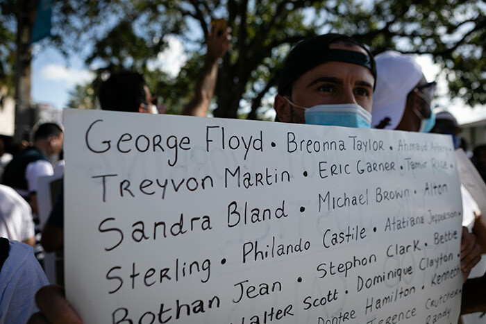 protestor holds a sign with the name of victims of police brutality during a rally in oral ables lorida on ay 30 2020 in response to the recent death of eorge loyd an unarmed black man who died while while being arrested and pinned to the ground by the knee of a inneapolis police officer hoto by va arie