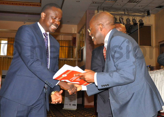 hairperson of the arliamentary ommittee on ealth r icheal ukenya  receiving a copy of the new guidelines from r bonye hoto by shraf asirye