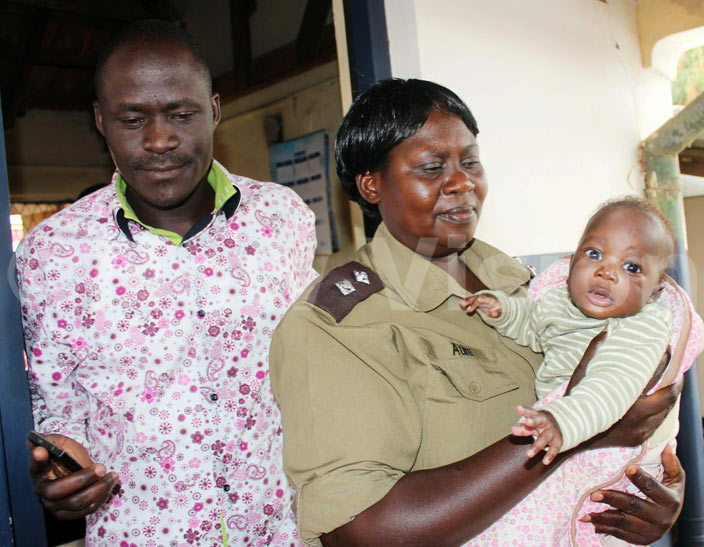  olice spokesman uma assan yene and lorence tim the incharge of family protection unit of police in oroti district carrying the baby
