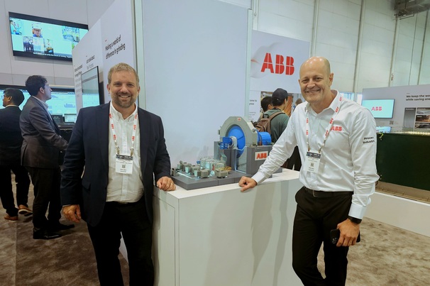 ABB's Francis Lacasse (left) and Wilson Monteiro next to a working model of a gearless mill drive, at MINExpo. Photo: Beth McLoughlin