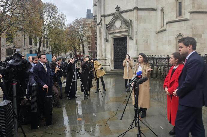 Caroline Narvaz Leite and Tom Ainsworth, from Pogust Goodhead, speak outside the High Court, London, today