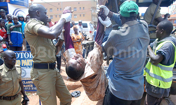 Omuvubuka nga bamussa ku kabangali ya Poliisi okumutwala e Mulago mu ddwaaliro Omuvubuka nga bamussa ku kabangali ya Poliisi okumutwala e Mulago mu ddwaaliro
