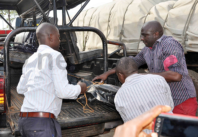 ecurity personnel load the body of immy tukuru on a olice vehicle hoto by ob antakiika
