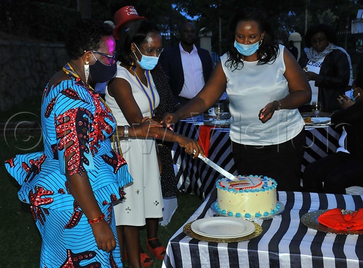 District Governor 9211 Rosetti Nabbumba  (left) Florence Lule President of Muyenga Sunday Sunset Rotary club cutting a cake during the Governor's visit.