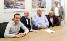  Dennis Sceghi, centre, signs the agreement with Michael Finnegan (second from left) 