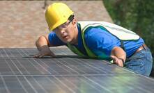 A worker installing solar panel assets