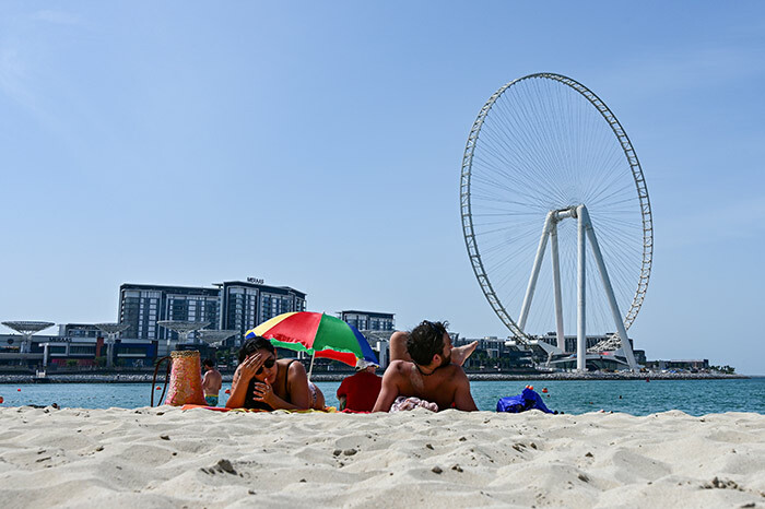 his picture taken on arch 20 2020 shows people sunbathing in the area of the umeirah each residence in ubai near the in ubai ubai ye ferris wheel despite fears of the spread of 19 coronavirus disease in the ulf region series of unprecedented shutdowns to counter the fastspreading coronavirus have impacted air travel closing restaurants and cinemas and shutting down government and business offices in some ulf states hoto by iuseppe