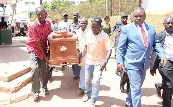 Lukwago (mu ssuuti) ng’akulembeddemu abaasitudde omulambo gwa Kaboogere okuva mu ggwanika e Mulago. Lukwago (mu ssuuti) ng’akulembeddemu abaasitudde omulambo gwa Kaboogere okuva mu ggwanika e Mulago.