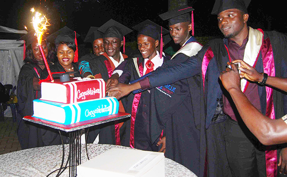 Collin Kayiwa (owookusatu ku ddyo) ng'asala keeki ne banne ku kabaga akamukoleddwa okumukulisa emisomo Collin Kayiwa (owookusatu ku ddyo) ng'asala keeki ne banne ku kabaga akamukoleddwa okumukulisa emisomo