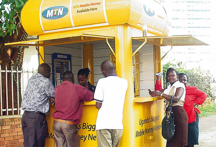  mobile money operator serving customers at an  booth in ampala
