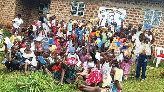   hildren pose with the scholastic materials  
