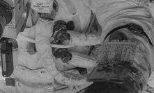 Apollo 12 astronaut holding a container of lunar soil