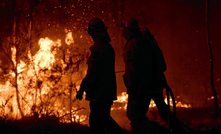 File photo: workers attend the site of a bushfire