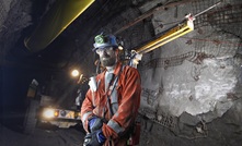 An underground drill rig operator in front of a MacLean drill