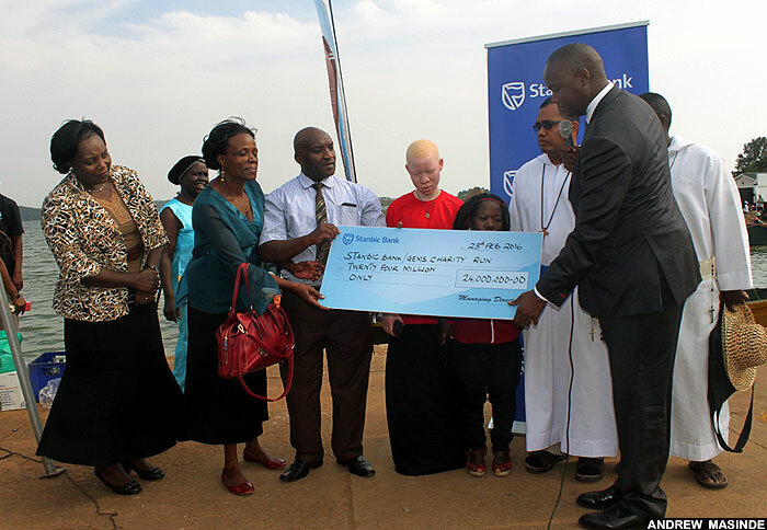  atrick weheire the hief xecutive tanbic bank ganda handing over a dummy cheque to the missionary of the poor children
