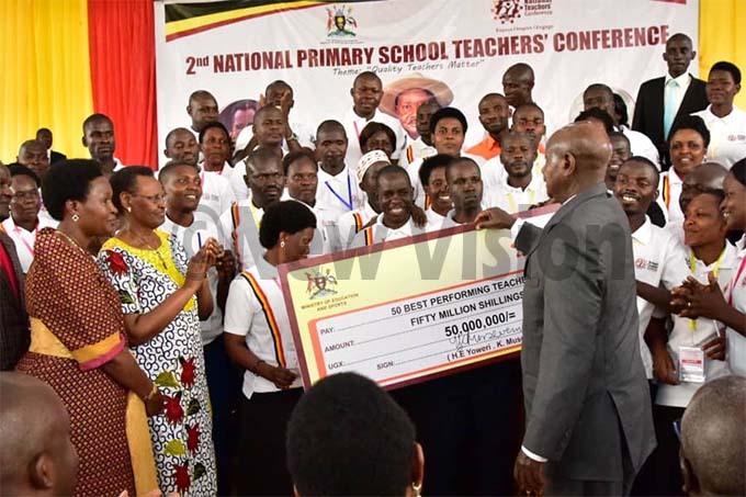  resident useveni hands over sh50 million dummy cheque to the best 50 teachers at the close of the threeday national primary school teachers conference in aya hoto by aria amala